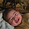 Josiah joined the competition — help win amazing prizes! baby, child, infant, smiling, laughing, face, portrait, close_up, indoors, blanket, couch, brown_clothing, patterned_background, cozy, happy, lying_down, home, soft_lighting, adorable, photograph