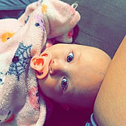 Baylor joined the competition — help win amazing prizes! baby, blanket, child, closeup, comfort, couch, curious, denim, eyes, face, indoor, infant, pacifier, person, pink, portrait, shorts, skin, soft, wrapped