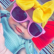 Baylor is registered to the contest to win money with this photo: baby, child, sunglasses, yellow_bow, headband, pink_sunglasses, mint_green_clothing, denim_shorts, red_top, outdoor, bench, cute, chubby_cheeks, fashion, summer, portrait, person, casual, relaxed, sunny