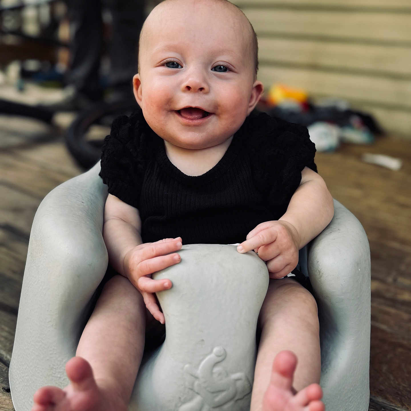 Baylor joined the competition — help win amazing prizes! baby, black_clothing, child, cute, expression, face, foot, hand, happy, indoors, infant, molded_seat, person, porch, seat, sitting, skin, small_toes, smiling, wood_floor