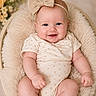 baby, smile, headband, bow, infant, cushion, basket, soft_texture, floral_background, cute, chubby, onesie, portrait, happy, skin, child, seated, indoor, closeup, adorable