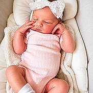 Myrah joined the competition — help win amazing prizes! baby, sleeping, infant, onesie, headband, bow, pink, white, blanket, cushion, cozy, cute, child, resting, soft, newborn, indoors, comfortable, peaceful, portrait