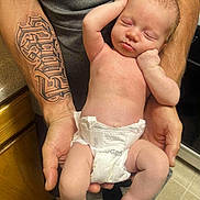 Faith joined the competition — help win amazing prizes! baby, sleeping, diaper, tattoo, arms, hands, indoor, floor, carpet, person, skin, newborn, peaceful, resting, infant, human, parent, closeup, holding, relaxation