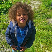 Kinsey participe au concours pour gagner de l'argent avec cette photo : blue_jacket, blue_shirt, casual_clothing, child, curly_hair, daylight, grass, gravel, greenery, happy, nature, outdoor, park, person, portrait, smiling, standing, sunny, toy_car, young