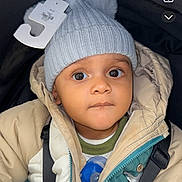 Brayden is registered to the contest to win money with this photo: baby, beanie, bodypart, bonnet, cap, clothing, coat, electronics, face, finger, hand, hat, head, hood, hoodie, knitwear, person, phone, sweater, sweatshirt