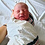 Curtis is registered to the contest to win money with this photo: newborn, baby, swaddled, blanket, striped_blanket, sleeping, infant, human_hand, resting, soft_lighting, bed, hospital, portrait, closeup, peaceful, person, head, face, skin, comfort