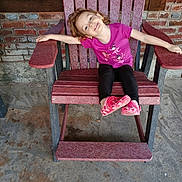 Raelynn joined the competition — help win amazing prizes! child, smiling, pink_shirt, black_pants, pink_shoes, wooden_chair, brick_wall, window, outdoor, concrete_floor, happy, girl, casual_clothing, relaxed_pose, playful, daylight, person, seated, portrait, fun