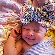 Everleigh is registered to the contest to win money with this photo: baby, sleeping, headband, bow, blanket, soft_texture, infant, cute, smile, wrapped, cozy, pink, lavender, floral, newborn, child, resting, peaceful, closeup, skin