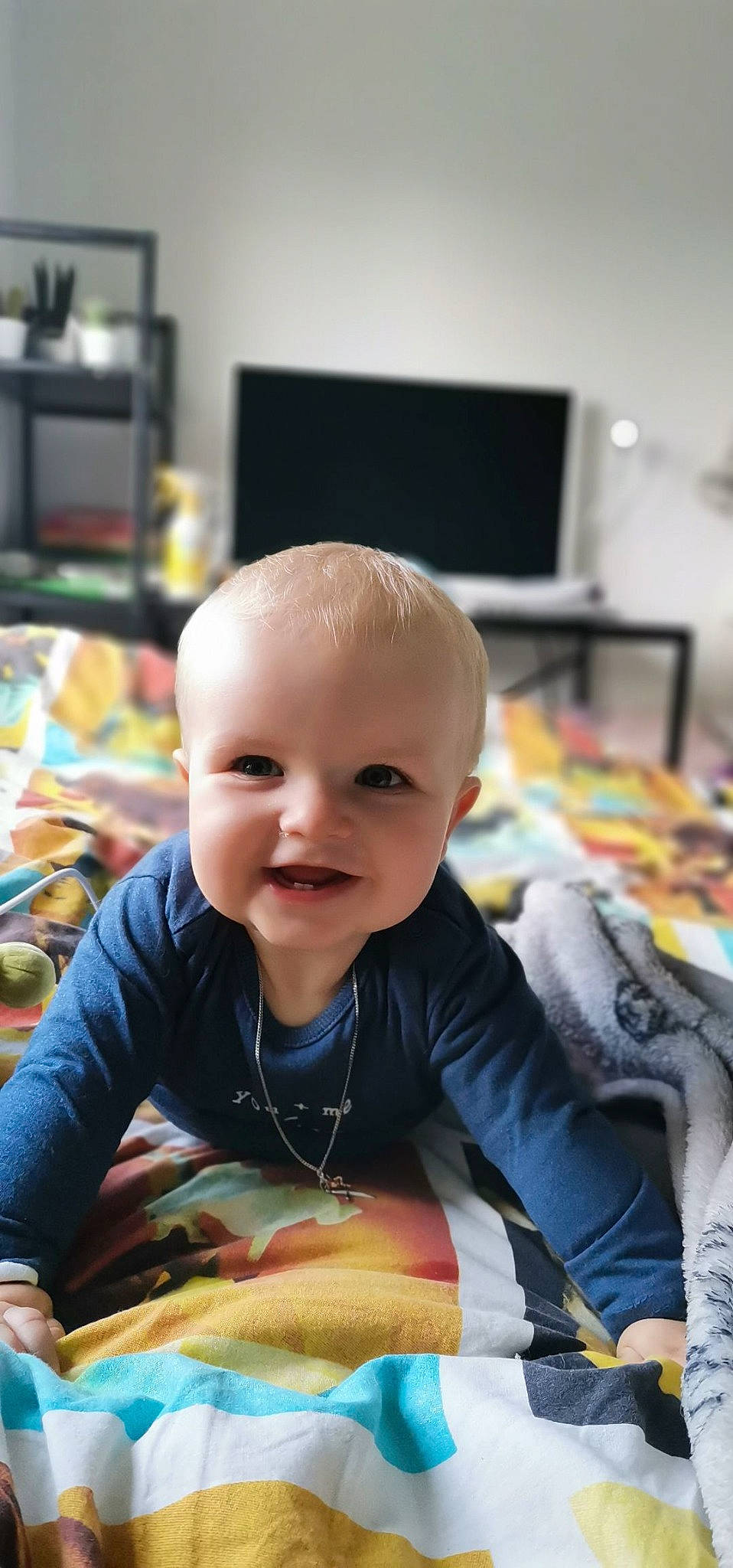 Paul participe au concours pour gagner de l'argent avec cette photo : baby, baby_toddler_clothing, cheek, child, chin, face, flooring, fun, happy, head, iris, joy, led_backlit_lcd_display, living_room, person, room, sitting, skin, smile, television