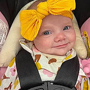 Drew joined the competition — help win amazing prizes! baby, child, smile, yellow_bow, headband, car_seat, safety_harness, floral_outfit, infant, cute, closeup, face, blue_eyes, pink, black_straps, seat_padding, indoors, person, happy, portrait