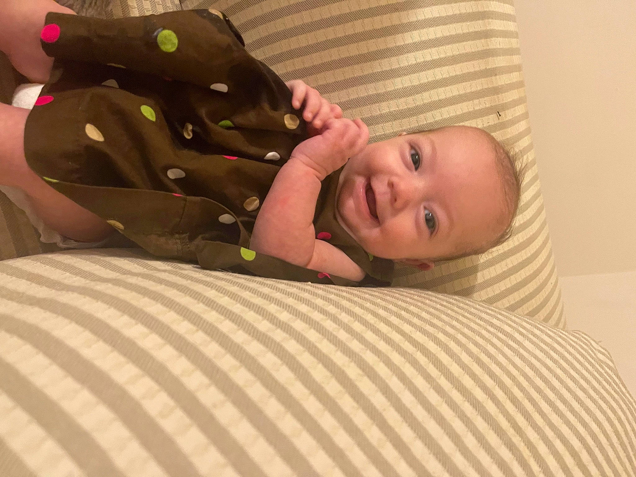 Gracelynn is registered to the contest to win money with this photo: arm, baby, baby_toddler_clothing, bed, bed_sheet, bedding, child, comfort, flooring, fun, hardwood, head, linens, person, room, sitting, skin, smile, textile, toddler