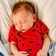 Robert joined the competition — help win amazing prizes! baby, newborn, sleeping, infant, red_onesie, blanket, bed, cozy, peaceful, cute, soft_lighting, portrait, human, child, indoors, resting, sleep, clothing, person, newborn_baby