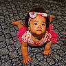 baby, baby_girl, child, closeup, crawling, curly_hair, cute, expression, feet, hands, headband, indoors, infant, looking_up, patterned_blanket, person, pink_clothing, portrait, soft_lighting, toddler