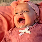 Evaana Dahal is registered to the contest to win money with this photo: baby, infant, pink_clothing, headband, bow, smiling, happy, cute, closeup, portrait, child, soft_light, indoors, skin, face, mouth_open, eyes, apparel, young_child, cozy
