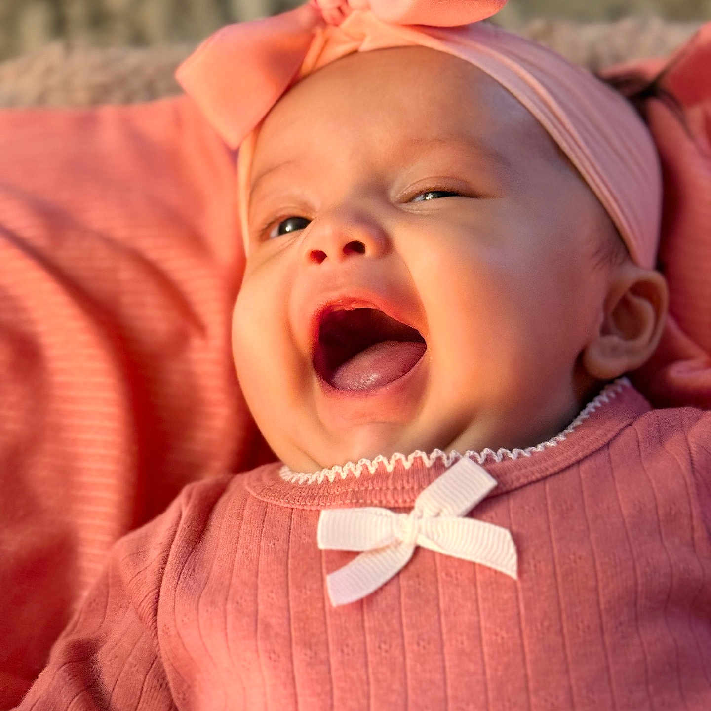 Evaana Dahal is registered to the contest to win money with this photo: apparel, baby, bow, child, closeup, cozy, cute, eyes, face, happy, headband, indoors, infant, mouth_open, pink_clothing, portrait, skin, smiling, soft_light, young_child
