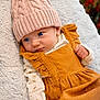 baby, blue_eyes, knitted_hat, pom_pom, mustard_dress, long_sleeve_onesie, soft_blanket, cozy, infant, cute, portrait, indoors, warm_clothing, child, small_hand, expression, closeup, face, newborn, casual_wear