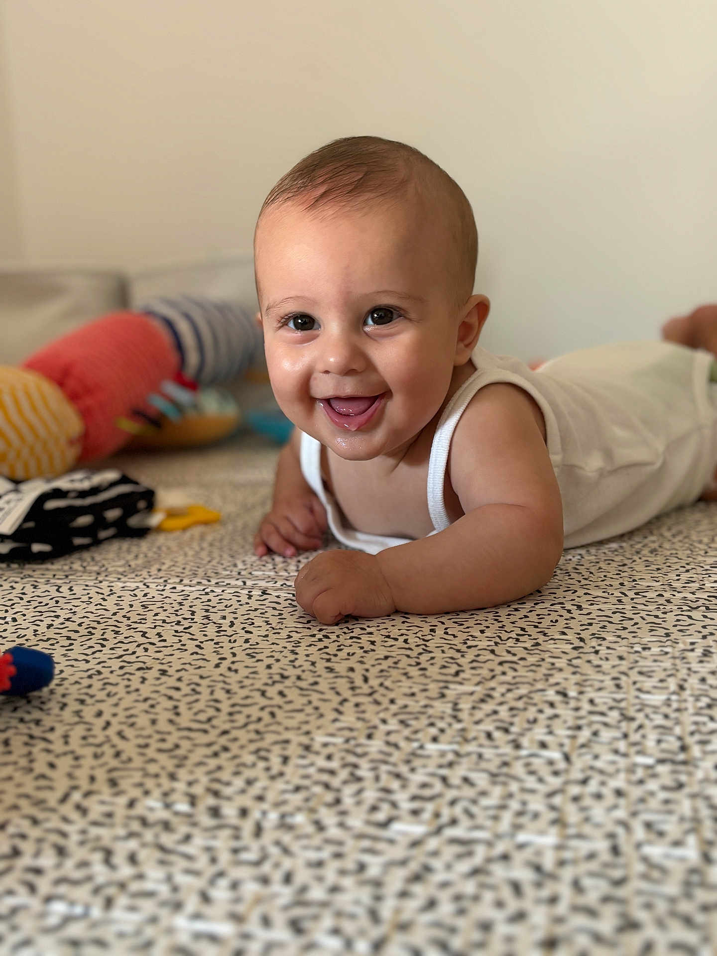 Lya participe au concours pour gagner de l'argent avec cette photo : baby, smile, face, infant, lying_down, blanket, toy, home, pattern, cute, child, happy, skin, person, indoor, clothing, soft_toy, closeup, toddler, play