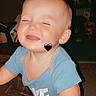 Cayson joined the competition — help win amazing prizes! baby, child, infant, smiling, laughing, portrait, close_up, indoor, living_room, blue_shirt, seated, face, eyes_closed, toy, television, furniture, home, heart_sticker, happy, candid