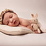 adorable, baby, blanket, bunny, closeup, cute, flower_crown, headband, indoors, infant, knitted_toy, neutral_background, newborn, peaceful, pillow, portrait, resting, skin, sleeping, soft_texture