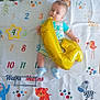 animal_illustrations, baby, balloon, blue_shoes, celebration, child, colorful, cute, elephant, giraffe, gold_balloon, infant, laying_down, milestone, milestone_blanket, monkey, numbers, striped_clothing, tiger, zebra