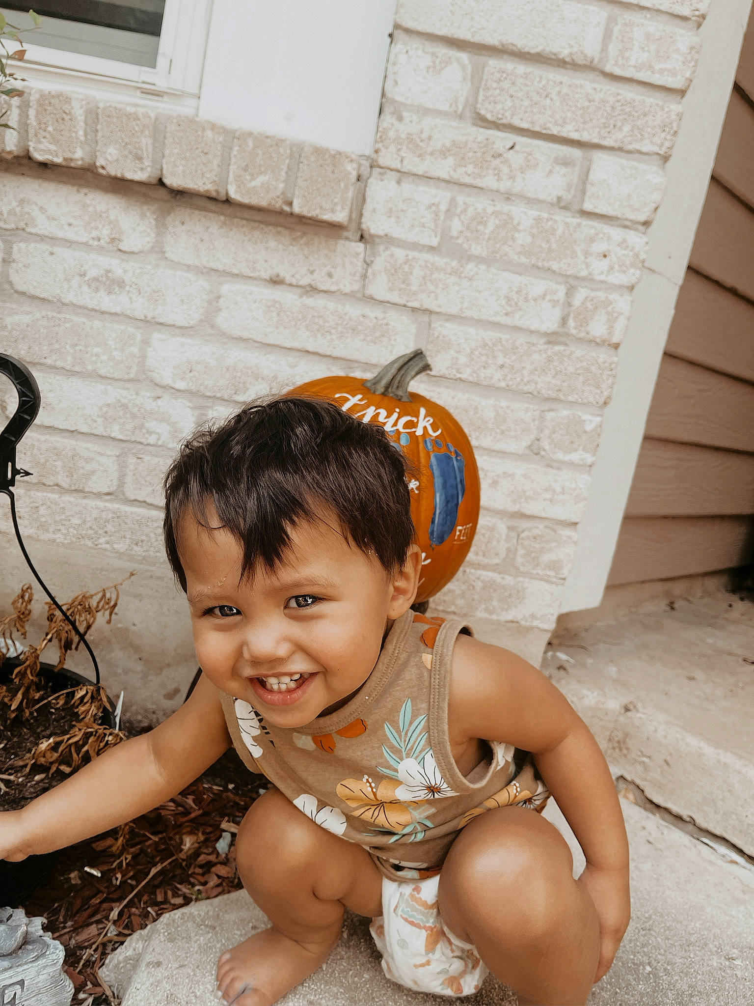 Koda is registered to the contest to win money with this photo: baby, bathing, brick, child, face, flash_photography, flooring, fun, grass, happy, head, joy, leisure, people_in_nature, person, plant, sitting, smile, soil, toddler