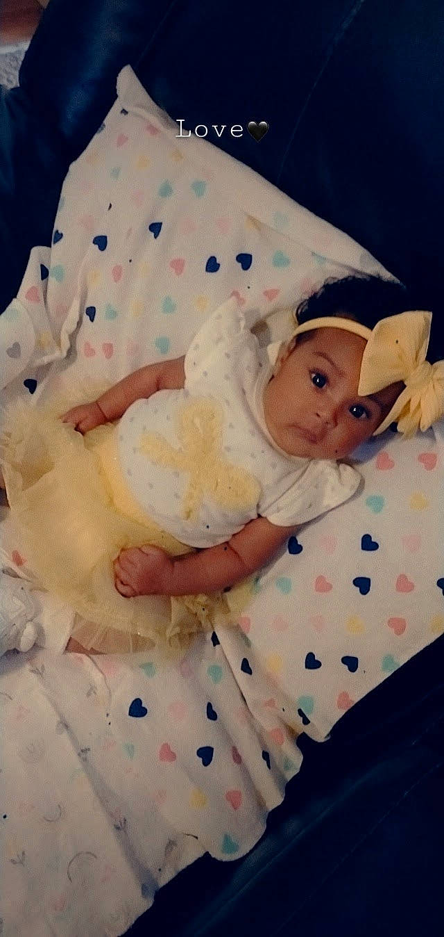 Elliana is registered to the contest to win money with this photo: baby, baby_products, baby_sleeping, baby_toddler_clothing, bedding, child, comfort, day_dress, embellishment, hand, happy, headwear, linens, pattern, person, pink, ruffle, sitting, skin, sleeve