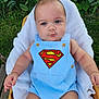 Alexzander is registered to the contest to win money with this photo: baby, child, superman_logo, romper, blue_clothing, towel, outdoor, greenery, grass, plants, infant, cute, portrait, sitting, skin, head, arms, legs, person, summer
