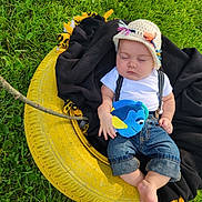 Alexzander is registered to the contest to win money with this photo: baby, sleeping, denim, hat, knit, plush_toy, blue, yellow_tire, blanket, grass, outdoor, cute, child, suspend, swing, nature, relax, peaceful, infant, clothing
