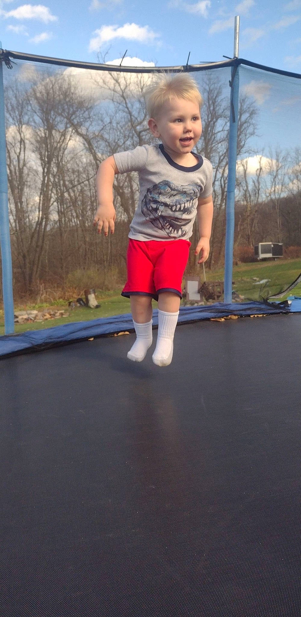 Jesse is registered to the contest to win money with this photo: asphalt, ball, barefoot, cloud, fun, grass, leisure, outdoor_play_equipment, person, plant, playground, recreation, shorts, sky, sports, t_shirt, toddler, trampoline, trampolining, trampolining_equipment_and_supplies