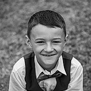 Lucio a rejoint le concours — aidez-le/la à gagner de superbes lots ! child, boy, smile, portrait, black_and_white, formal_clothing, bow_tie, vest, shirt, outdoor, grass, happy, young, face, person, head, short_hair, casual_pose, monochrome, kid