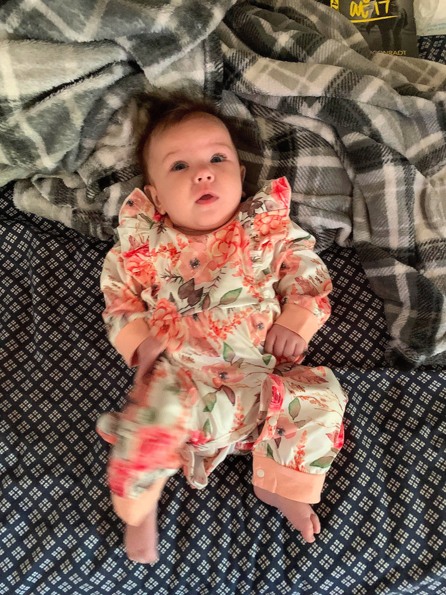 Havanna is registered to the contest to win money with this photo: baby, baby_toddler_clothing, child, comfort, face, foot, fun, happy, head, human_body, linens, outerwear, pattern, peach, person, plaid, skin, sleeve, textile, thigh