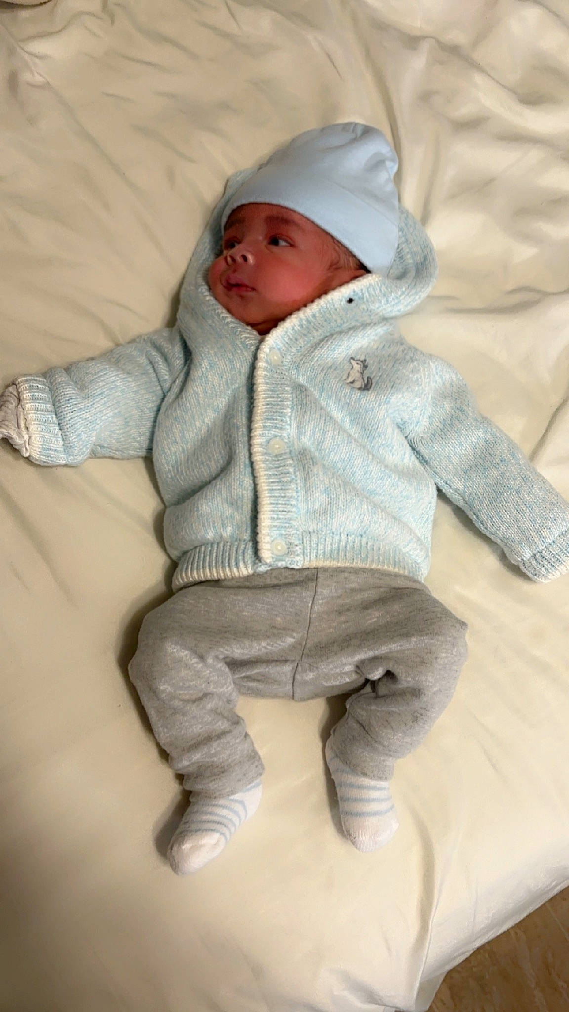 Terrence joined the competition — help win amazing prizes! baby, baby_sleeping, baby_toddler_clothing, cap, cheek, child, clothing, collar, comfort, face, headwear, knit_cap, linens, outerwear, person, sitting, skin, sleeve, toddler, wood