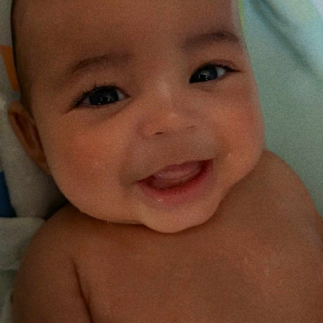 Terrence is registered to the contest to win money with this photo: baby, blanket, bodypart, bonnet, clothing, face, finger, happy, hat, head, laughing, mouth, newborn, person, photography, portrait, selfie, smile, teeth, towel