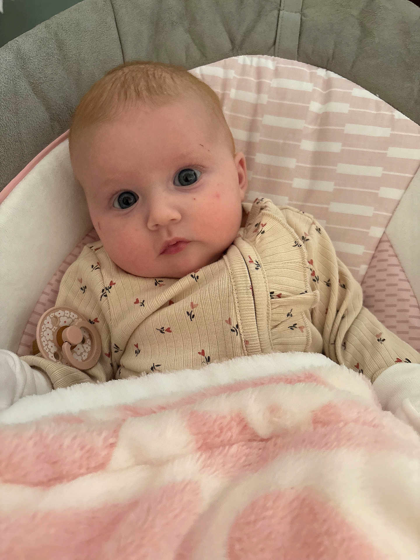 Evelyn joined the competition — help win amazing prizes! baby, infant, face, eyes, clothing, pacifier, blanket, seat, cushion, pink, beige, pattern, cute, child, portrait, indoors, soft, warm, cozy, expression