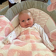 Evelyn is registered to the contest to win money with this photo: baby, blanket, baby_seat, smile, face, infant, soft_toy, pink, white, cushion, clothing, indoor, comfort, cute, child, person, portrait, happy, home, cozy