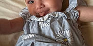 Keyonna-Lee joined the competition — help win amazing prizes! baby, child, face, headband, bow, tongue, daisy_pattern, dress, clothing, lying_down, skin, arms, expression, cute, playful, infant, portrait, indoors, soft_light, smiling