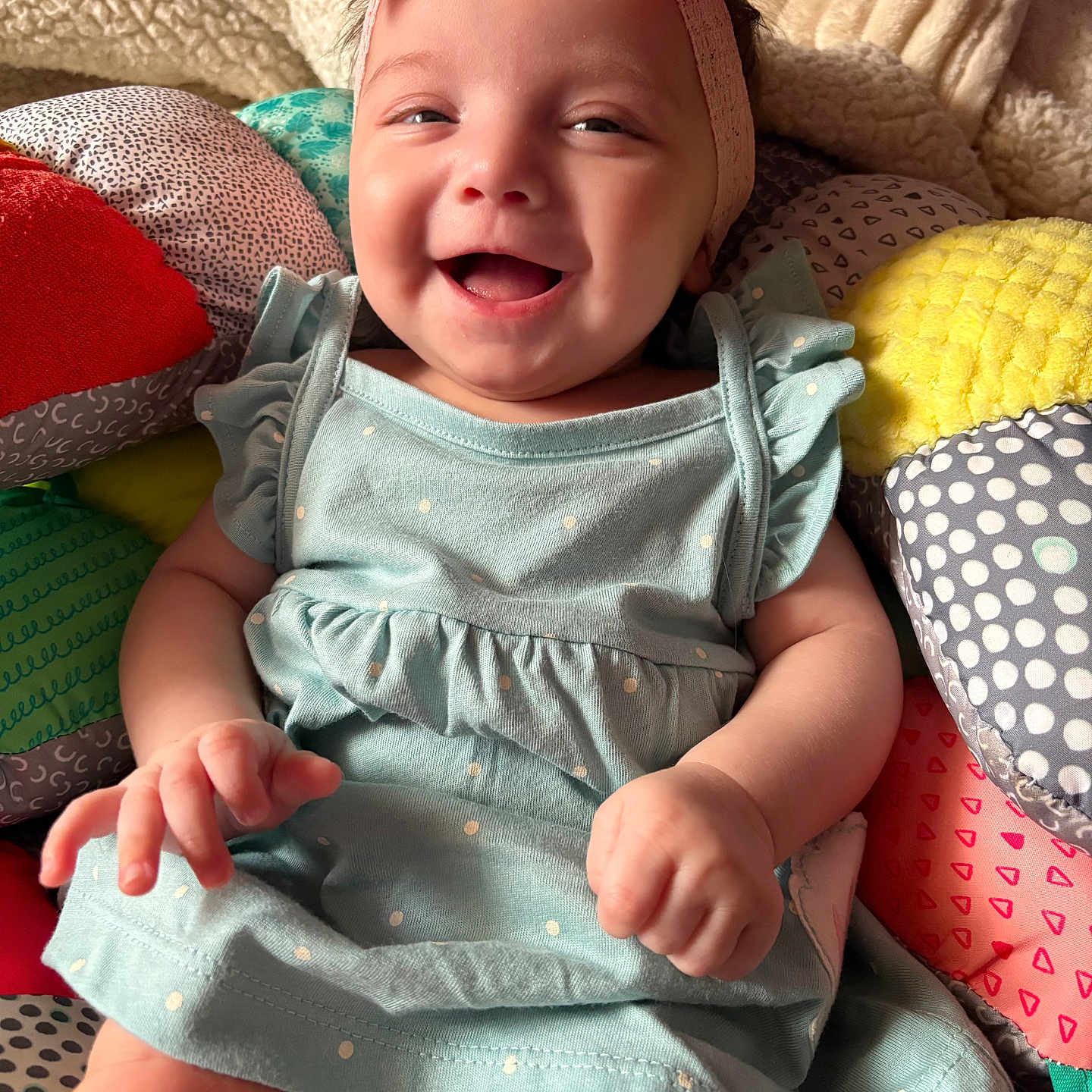Keyonna-Lee is registered to the contest to win money with this photo: baby, blanket, bow, child, colorful, cozy, cushion, cute, dress, face, hands, happy, headband, indoor, infant, polka_dot, portrait, sitting, smiling, soft
