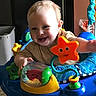 Daxton is registered to the contest to win money with this photo: baby, child, smiling, toy, activity_center, indoor, colorful, playful, happy, face, person, blue, orange, green, plastic, infant, cute, early_childhood, fun, development