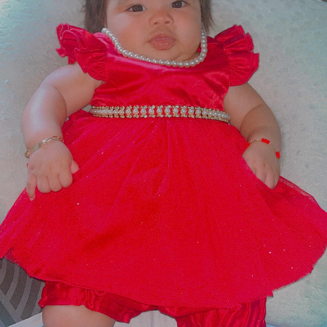 Georgina joined the competition — help win amazing prizes! accessories, adorable, baby, baby_clothing, bed, blanket, bracelet, chubby_cheeks, cushion, cute, footwear_off, indoor, infant, lying_down, pearl_necklace, person, portrait, red_dress, relaxed, soft_texture