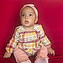 Magarteh joined the competition — help win amazing prizes! baby, child, infant, sitting, couch, red_couch, headband, pink_clothing, plaid_shirt, socks, indoors, pillow, patterned_pillow, curious_expression, wide_eyes, cute, portrait, person, furniture, home