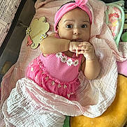 Magarteh is registered to the contest to win money with this photo: baby, infant, child, pink_dress, headband, blanket, playpen, soft_toys, sucking_fingers, cute, portrait, indoors, laying_down, floral_pattern, cozy, young_child, peaceful, curious, comfortable, closeup