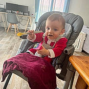 Celestin participe au concours pour gagner de l'argent avec cette photo : baby, high_chair, spoon, red_clothing, indoor, floor, table, curtains, window, computer, chair, desk, child, person, happy, feeding, snack, home, furniture, toddler
