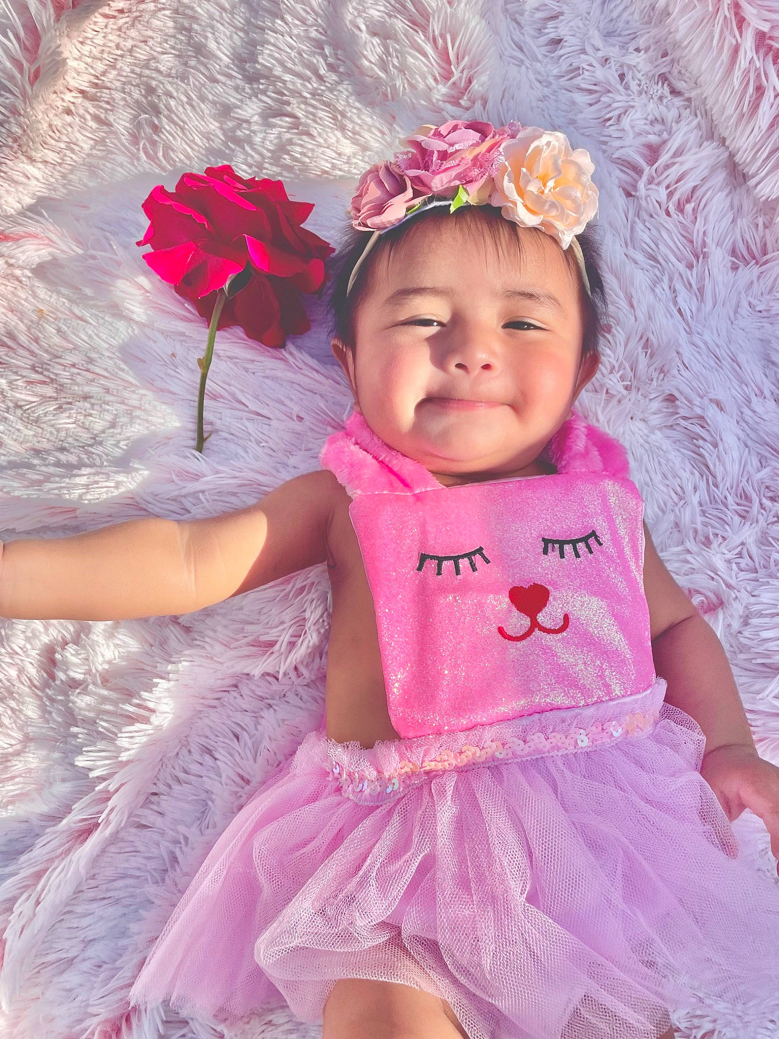 Rosie Love joined the competition — help win amazing prizes! baby, baby_toddler_clothing, child, dress, embellishment, eye, fun, happy, headgear, headpiece, headwear, iris, joy, magenta, person, petal, pink, plant, purple, skin