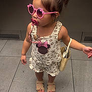 Maddie joined the competition — help win amazing prizes! child, toddler, girl, sunglasses, pacifier, hair_bun, hair_clip, dress, romper, handbag, sandals, elevator, indoor, tile_floor, fashion, accessories, standing, portrait, cute, minnie_mouse