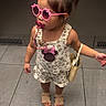 child, toddler, girl, sunglasses, pacifier, hair_bun, hair_clip, dress, romper, handbag, sandals, elevator, indoor, tile_floor, fashion, accessories, standing, portrait, cute, minnie_mouse