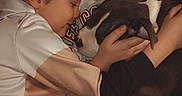 Laïka participe au concours pour gagner de l'argent avec cette photo : children, boys, puppy, dog, pet, cuddling, hugging, sleeping, smiling, portrait, indoors, couch, family, companionship, brown_hair, white_shirt, sweatshirt, jeans, cozy, wholesome