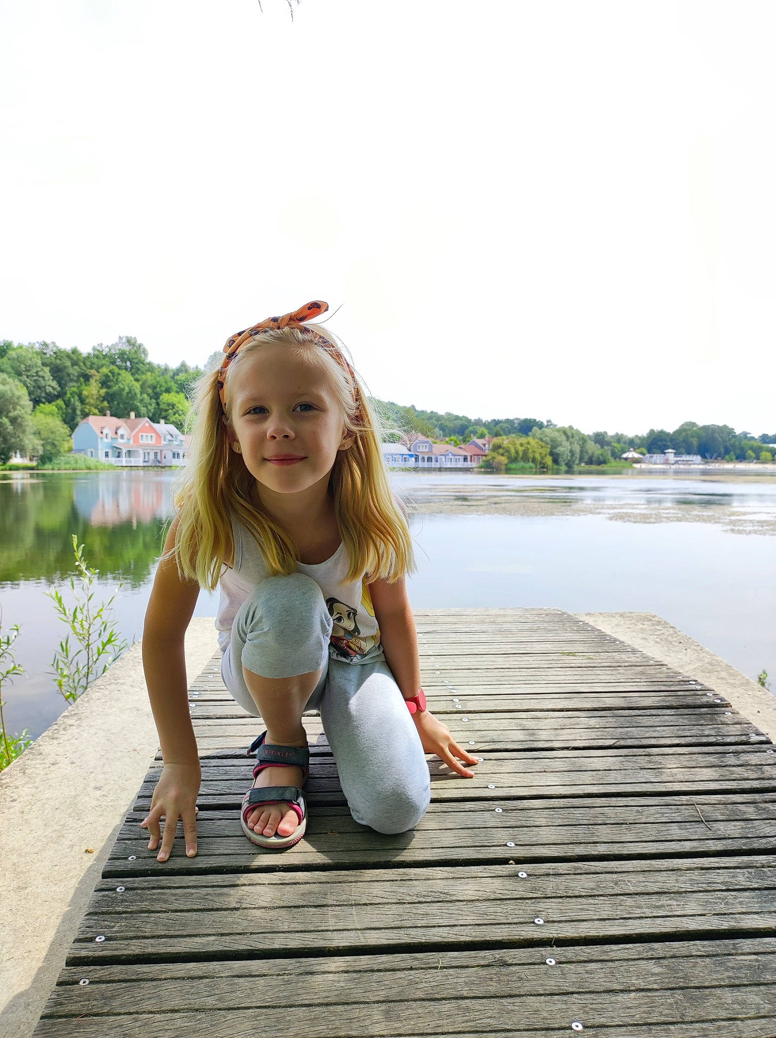 Éléana participe au concours pour gagner de l'argent avec cette photo : bank, blond, dock, flash_photography, fun, grass, happy, human_leg, joy, lake, leg, leisure, long_hair, person, plant, recreation, sky, smile, thigh, tree