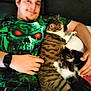 Vénus a rejoint le concours — aidez-le/la à gagner de superbes lots ! animal, cat, couch, cozy, facial_hair, feline, green_shirt, hand, happy, indoors, kitten, man, person, pets, relaxing, shirt, smile, snuggling, tabby_cat, watch