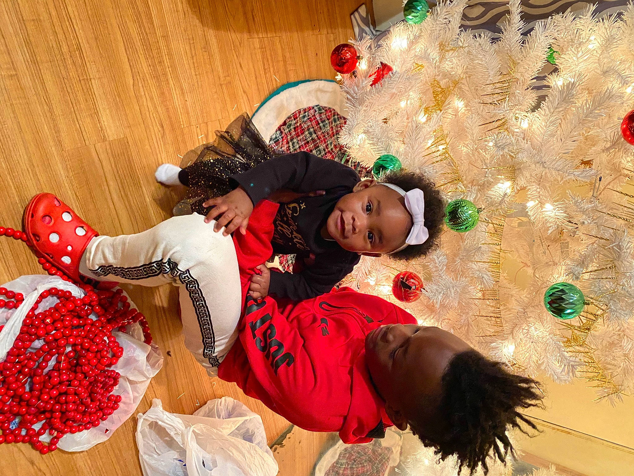 Allure is registered to the contest to win money with this photo: child, christmas, christmas_decoration, christmas_eve, christmas_ornament, christmas_tree, event, flooring, fun, happy, holiday, leisure, person, plant, room, sock, textile, toddler, tradition, tree