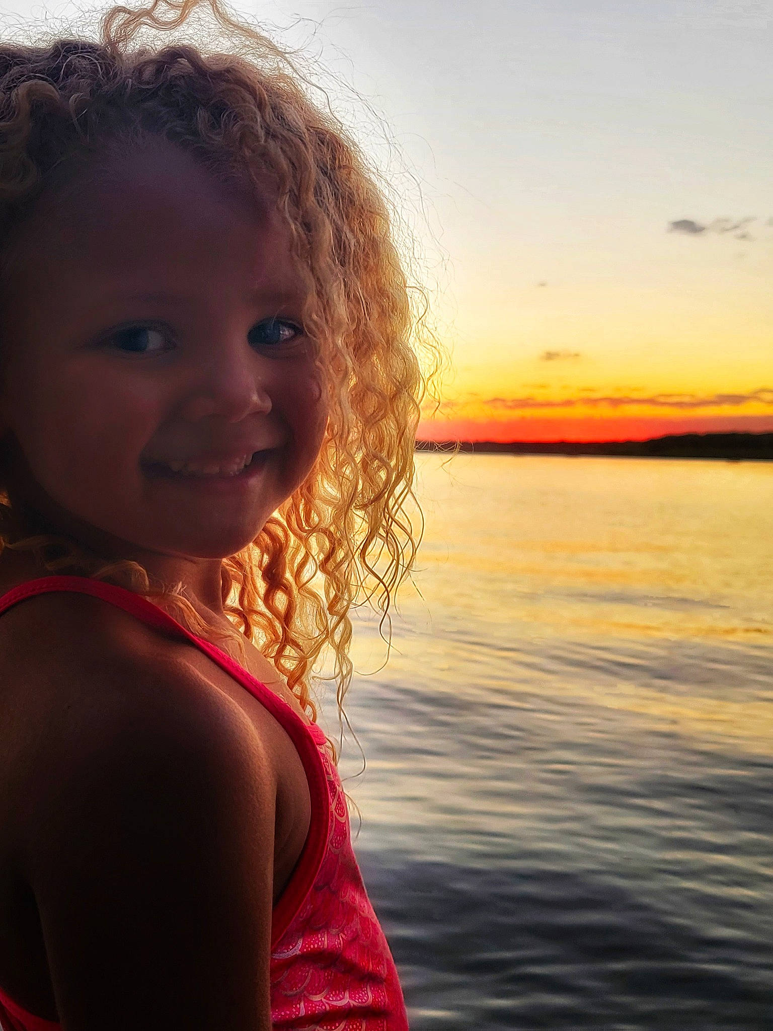 Amiah is registered to the contest to win money with this photo: body_of_water, cloud, eye, flash_photography, fun, hair, happy, joy, lake, lip, long_hair, magenta, people_in_nature, person, skin, sky, smile, standing, sunlight, toddler